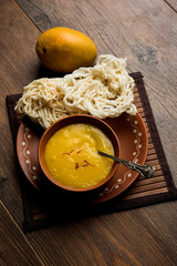 Aam Ras or Alphonso mango pulp with kurdai which is a fried dish made using wheat/gehu. selective focus