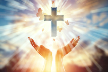 Close-up hands on the background of the symbol of Christian, prayer, catholic cross, a flock of...