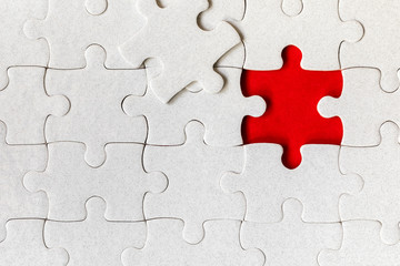 Fototapeta premium White jigsaw puzzle. White puzzle pieces on color background. Unfinished white jigsaw puzzle pieces on color background.