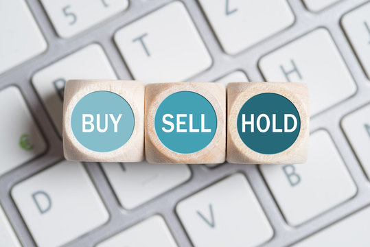 Würfel mit Optionen "Buy", "Sell" und "Hold" auf Computer Tastatur