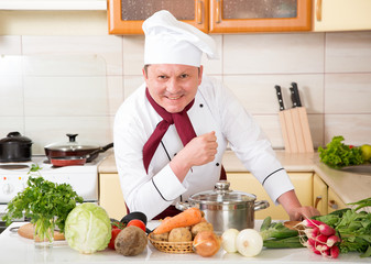 Portrait of a male cook in the kitchen. Male chef cooks food.