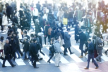 blurred photo of people busy crossing the street. the picture is miniature siyle with soft light