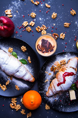 Delicious breakfast with fresh croissants and coffee served with butter and honey.