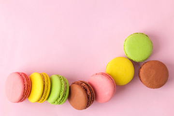 Macarons. french multicolored macaroons cakes. small french sweet cake on bright pink background. Dessert. Sweets. top view