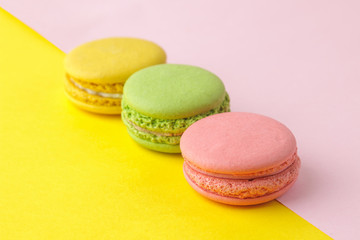 Fototapeta na wymiar Macarons. french multicolored macaroons cakes. small french sweet cake on a bright multi-colored pink and yellow background. Dessert. Sweets.