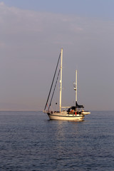 The yacht sails moored on the open sea