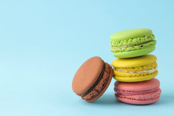 Macarons. french multicolored macaroons cakes. small french sweet cake on bright blue background. Dessert. Sweets.