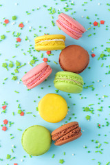 Macarons. french multicolored macaroons cakes. small french sweet cake on bright blue background. Dessert. Sweets. top view.