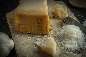 Grated parmesan cheese on black background, italian food.
