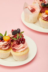 two plates with sweet cakes on pink surface