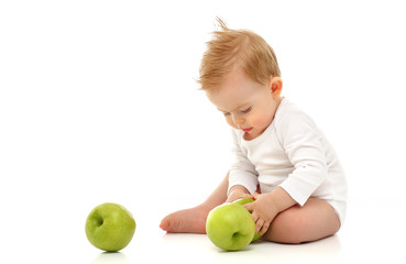 Fototapeta na wymiar Baby 11 months old in white bodysuit sitting on white background with green apples