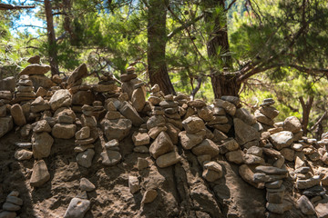 Fototapeta na wymiar Samaria Gorge. Tourist tradition - a way of stones in the form of slides, in series or in the form of a pyramid. Island of Crete, Greece.