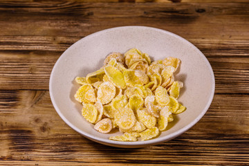 Ceramic plate with cornflakes on a wooden table. Healthy eating