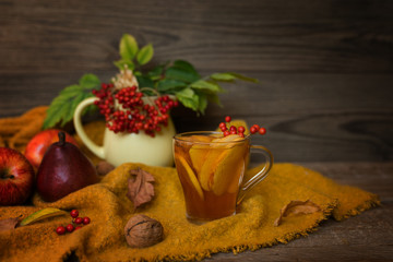 Autumn, fall leaves, hot cup of tea on wooden table background. Seasonal, autumnal hot drink. Autumn relaxing and still life concept.