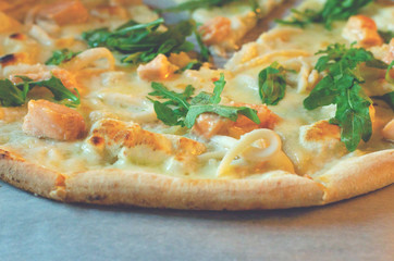Closeup of pizza with seafood and arugula.