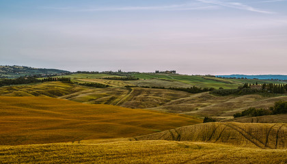 Obraz premium View of a autumn day in the Italian rural landscape. Unique sundown tuscany landscape in fall time. Wave hills, cypresses trees and cloudly sky. Tuscany, Italy, Europe