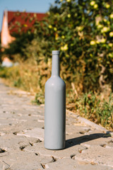 one gray bottle on the road from the tiles, the village, rural alcoholism, drunkenness. alcoholic illness. wine natural drink. wine