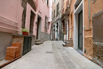 narrow street with pink Italian houses in Vernazza, Cinque Terre, the Ligurian coast of the Mediterranean