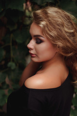  Stylish handsome  curly blonde wearing chic little black dress. Glamour girl posing and smiling at camera.