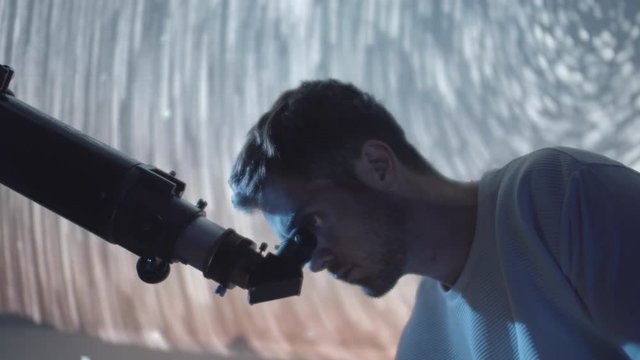 Astronomer Man in moonlight looking at sky using telescope with stars swirling