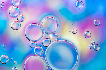 Beautiful macro photo of water droplets in oil with a colorful background.
