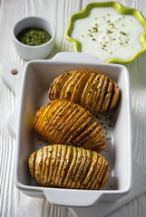 Hasselback potatoes baked with garlic and herbs in oven.