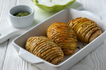 Hasselback potatoes baked with garlic and herbs in oven.