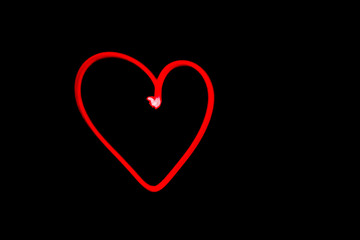 red heart outline light painting in black night sky
