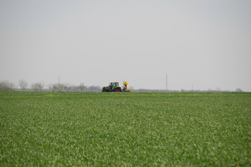 Tractor cultivating field at spring