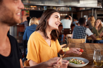 Couple On Date Meeting For Drinks And Food Making A Toast In Restaurant