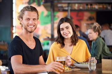 Portrait Of Couple On Date Meeting For Drinks And Food In Restaurant