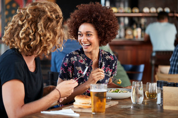 Couple On Date Meeting For Drinks And Food In Restaurant