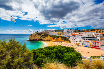 View of Carvoeiro fishing village with beautiful beach, Algarve, Portugal. View of beach in Carvoeiro town with colorful houses on coast of Portugal. The village Carvoeiro in the Algarve Portugal.