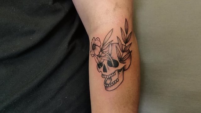 Skull tattoo on male arm.