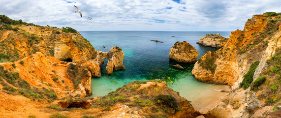 View of stunning beach with golden color rocks in Alvor town , Algarve, Portugal. View of cliff rocks on Alvor beach, Algarve region, Portugal.