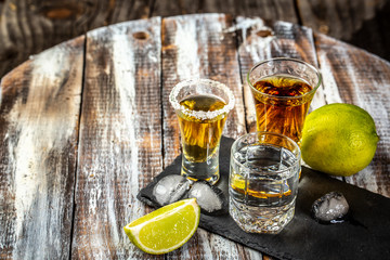 Different alcoholic drink in glass. Mexican tequila with lime and salt on rustic wood background....