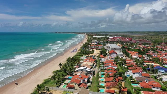 Aerial view of tourist resort town Porto de Galinhas, white sand beach and turquoise bright-water of Atlantic Ocean - landscape panorama of Brazil from above, South America