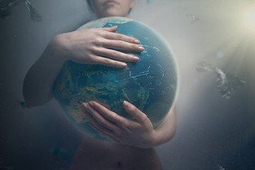 Woman embracing the globe of planet Earth. The concept of preserving the environment and love for...