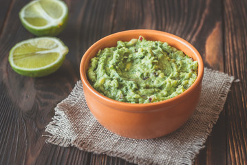 Bowl of guacamole on the wooden table