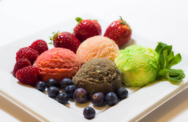 Set of ice cream scoops of different colors and flavours with fruits decoration isolated on white background 