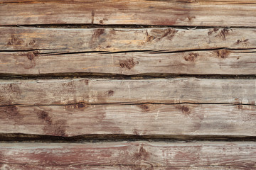 Beautiful wooden background from old weathered horizontal logs with knots and moss. view of the wal