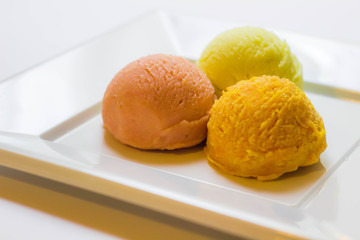 Set of ice cream scoops of different colors and flavours with fruits decoration isolated on white background 