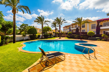 Swimming pool with stair. Grab bars ladder in the blue swimming pool. Poolside with blue clear...