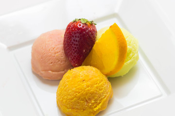 Set of ice cream scoops of different colors and flavours with fruits decoration isolated on white background 
