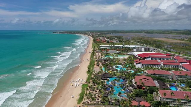 Aerial view of tourist resort town Porto de Galinhas, white sand beach and turquoise bright-water of Atlantic Ocean - landscape panorama of Brazil from above, South America