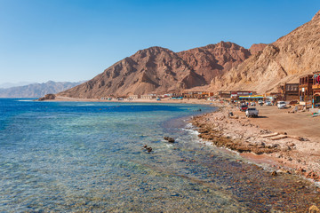 Sunny resort beach at the coast shore of Red Sea in Dahab, Sinai, Egypt, Asia in summer hot. Famous...