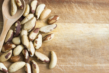 Brazil nuts, healthy raw snack on wooden chopping board  