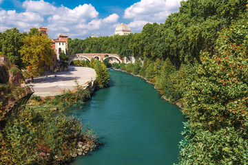 Fototapeta premium Skyline landscape of beautiful Roma from the Tiber shore in a clear blue sky and sunny day. Famous tourist destination in Italy