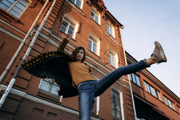 Young woman raises her leg up outdoor in evening