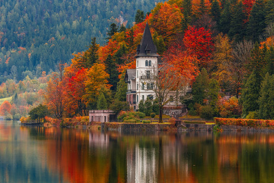 Villa Castiglioni in colorful forest reflected in water, lake Grundlsee
